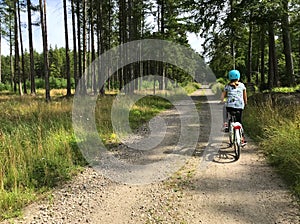 Young girl riding a bike on a gravel path