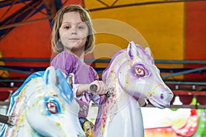 Young girl riding carousel horses