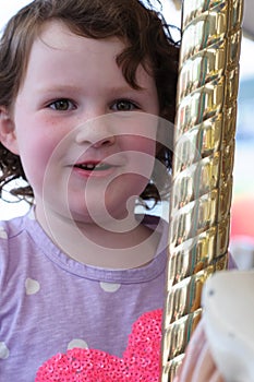 Young girl riding on fairground horse on carousel amusement ride at fairgrounds park outdoor