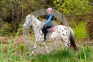 young girl riding her pony in a beautiful landscape of the Landes forest