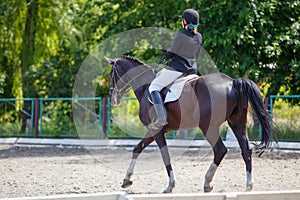 Young girl riding horse on equestrian competition