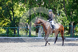 Young girl riding horse on equestrian competition
