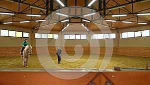 Young girl riding horse indoors.