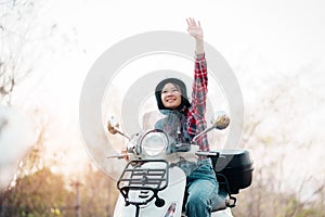 Young girl riding a motor scooter on road.