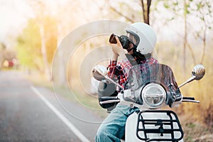 Young girl riding a motor scooter on road.