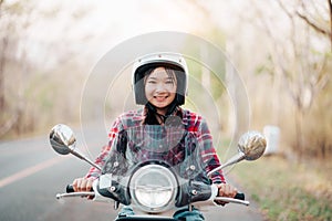 Young girl riding a motor scooter on road.Travels by scooter slow life in the countryside