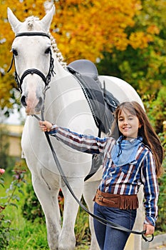 Young girl riding on white dressage horse