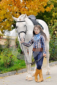 Young girl riding on white dressage horse