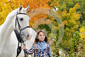 Young girl riding on white dressage horse