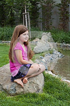 Young Girl on Rock by Calm Stream