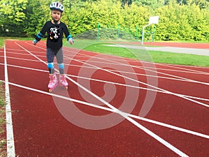Young girl rollerskating in red running track