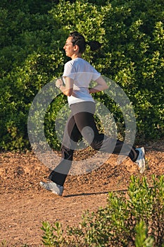 Young girl runner on the springtime on the forest road