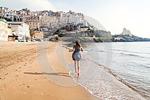 Young girl running on the beach of Sperlonga, Italy