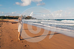 Young girl running down the beach in a swimming suite