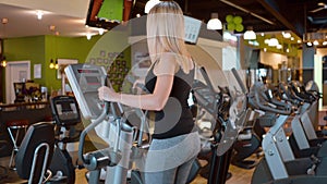 Young and girl is running on a stepper at the gym