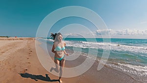 Young Girl Runs along the Beach of the Sea Coast in Slow Motion