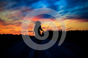 a girl runs along a field road without touching the ground in the evening at sunset a silhouette against the multicolored sky 2