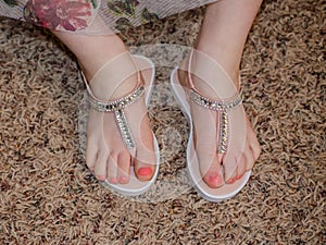 Young girl`s feet wearing sparkle fancy shoes. photo