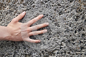 Young girl`s hand touching an ancient stone with cuneiform writings