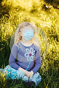 Young girl in sanitary face mask covering her face. Child wearing protective mask against coronavirus outdoors. Concept of panic,