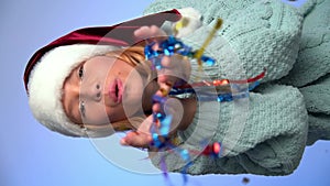 Young girl in Santa Claus cap playing with colorfull confetti and celebrate christmas