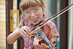 Young Girl At School Learning To Play Violin