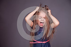 Young girl is screeming and holding her hair photo