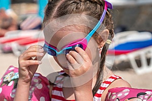 Young girl by the sea puts on her diving googles