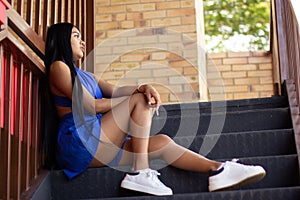 Young girl seated on stairs. beautiful latin girl with long legs.