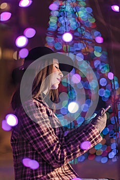 Young girl sending sms christmass wishes during winter alone in