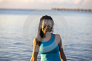 Young girl with sexy smile in the water of the caribbean sea of Mexico's mayan riviera under a warm sunrise.