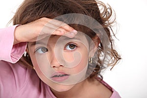 Young girl shielding her eyes photo