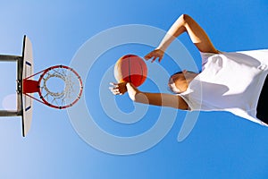 Young girl shooting basket outdoors