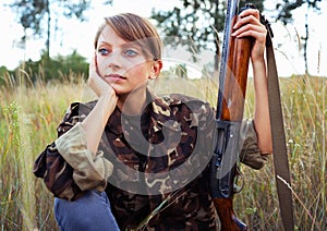 Young girl with a shotgun in an outdoor