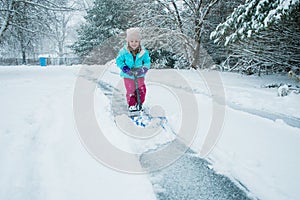 A young girl shoveling snow