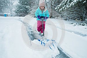A young girl shoveling snow in a winter storm
