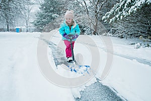 A young girl shoveling snow in a winter storm