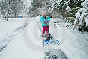 A young girl shoveling snow in a winter storm