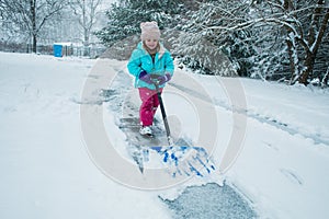 A young girl shoveling snow in a winter storm