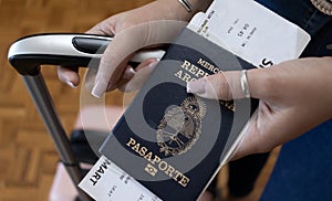 Young girl showing the Argentine passport with her travel bags. photo