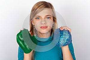 Young girl showing a green and a blue slime