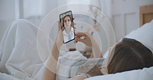 Young Girl Sick at Home Using Smartphone to Talk to Her Doctor via Video Conference Medical App. Beautiful Woman Checks