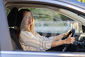 Young girl sit at driver seat in new car smiling hold hands on wheel happy to get driver license