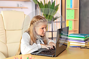 A young girl sits at a computer in the office.