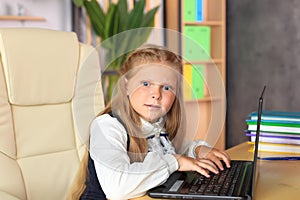 A young girl sits at a computer in the office.