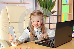 A young girl sits at a computer in the office.