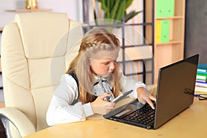 A young girl sits at a computer in the office.