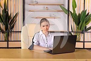 A young girl sits at a computer in the office.