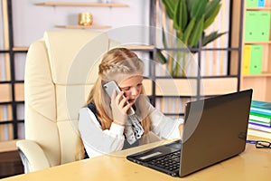 A young girl sits at a computer in the office.