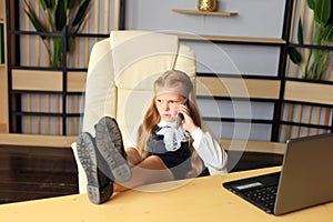 A young girl sits at a computer in the office.